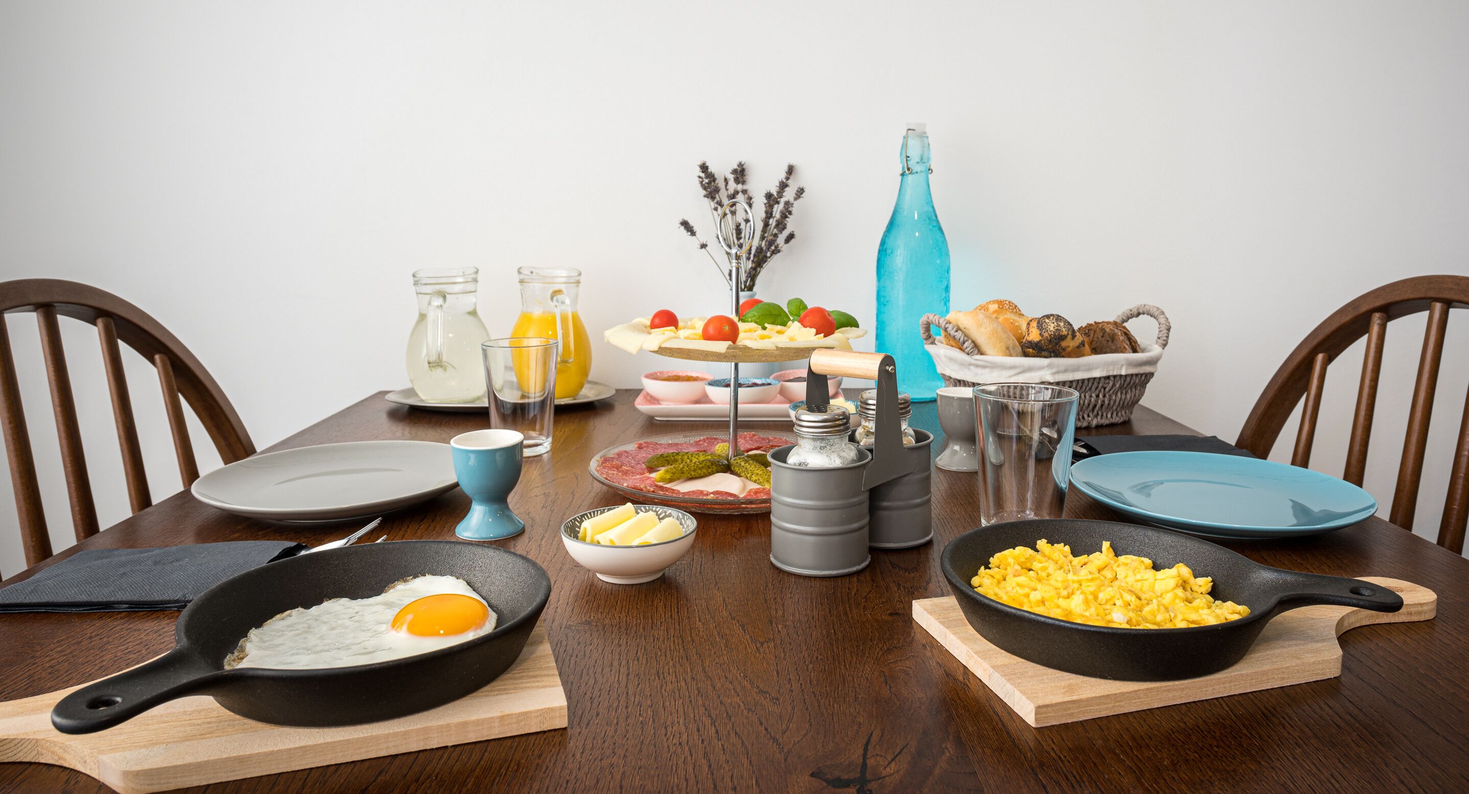Een ontbijttafel met diverse gerechten, zoals roerei, toast en een fruitschaal.