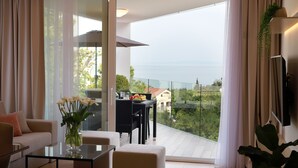 Un salon moderne avec une table en verre, un canapé et une vue sur la mer.