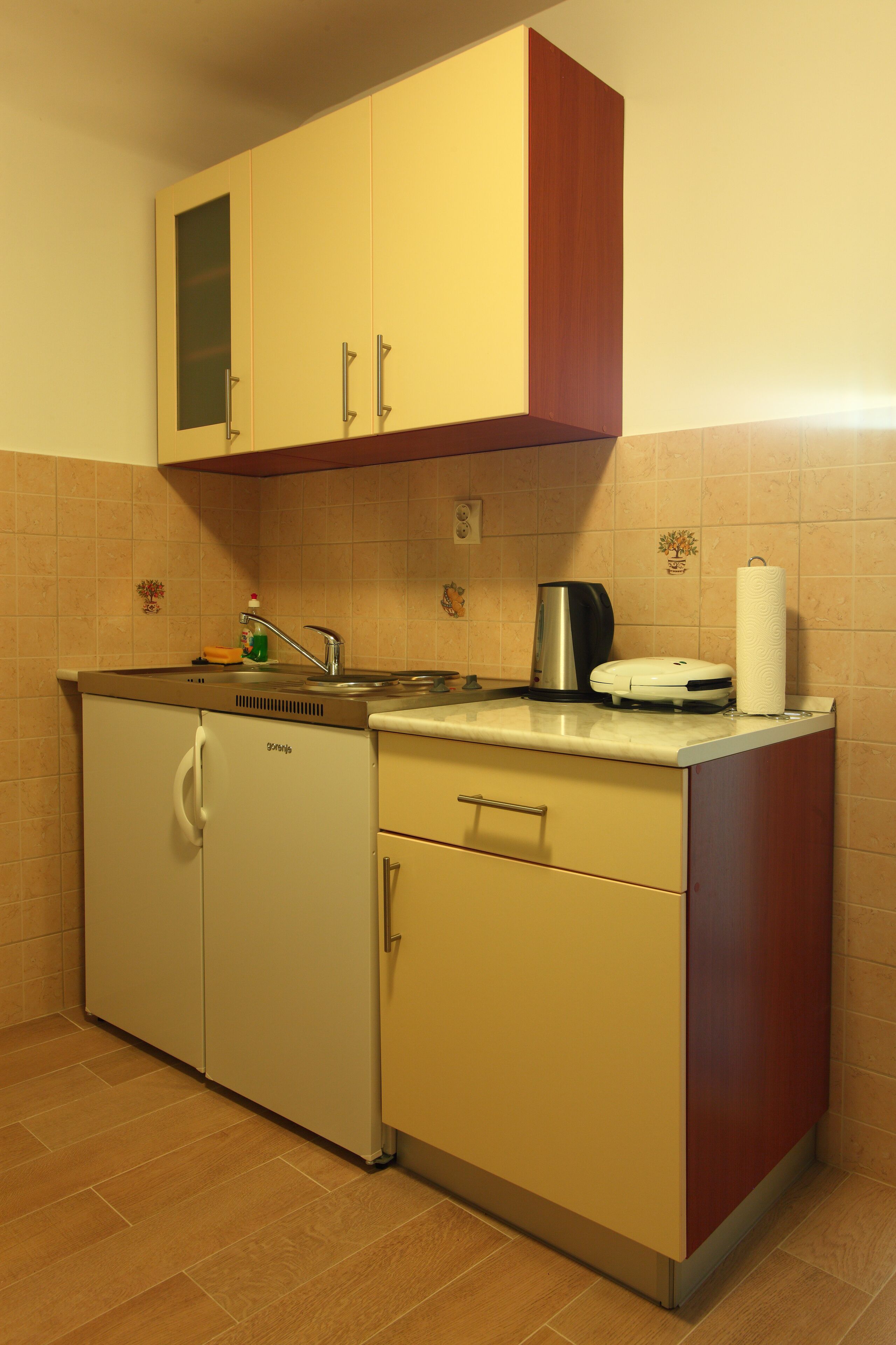 A compact kitchen with a sink, a coffee maker, and a toaster.