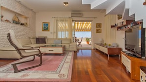 A spacious living room with a sofa, armchairs, a coffee table, and a television. - Villa Mia (Dubrovnik)