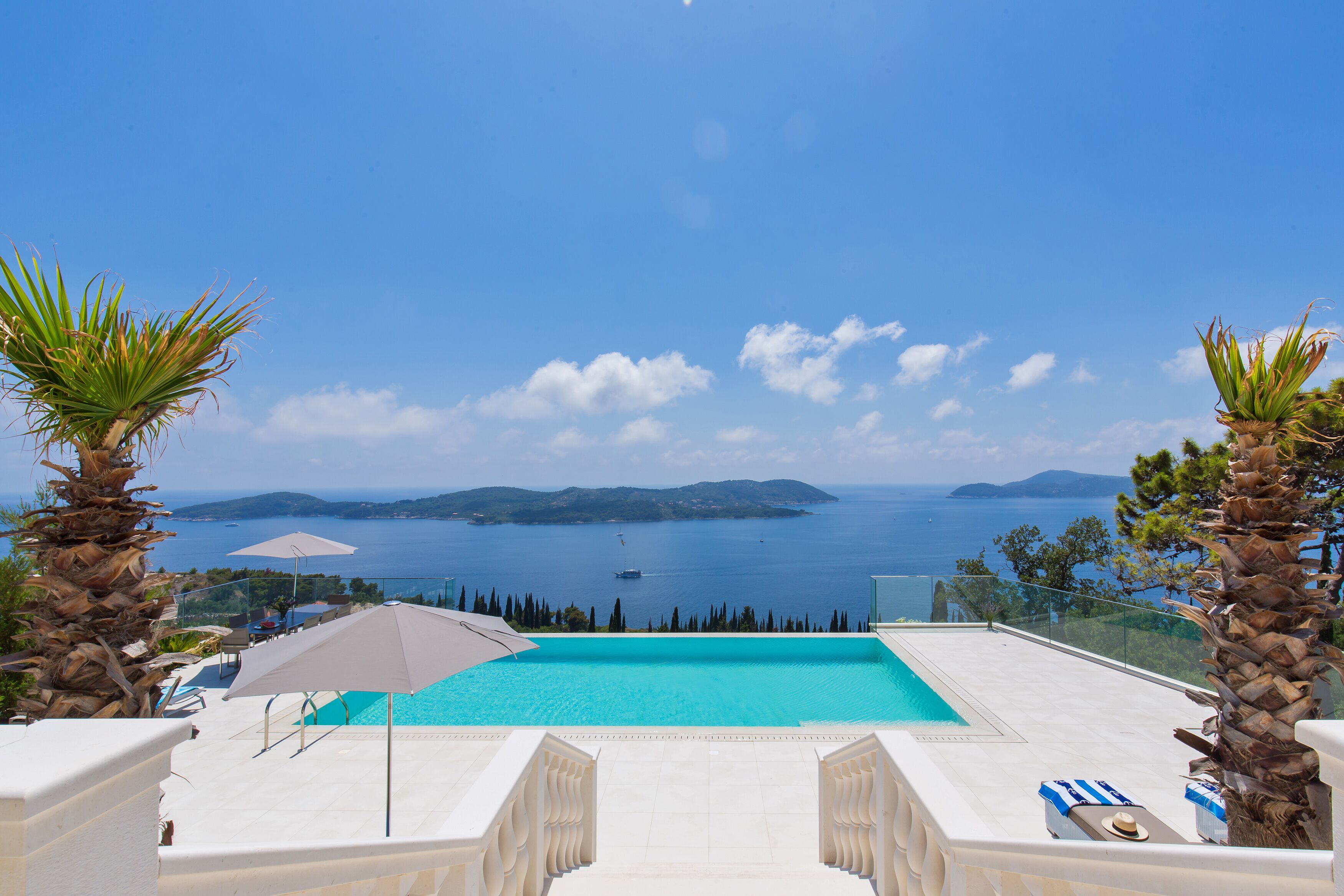 Piscina com vista desobstruída para o mar e montanhas.
