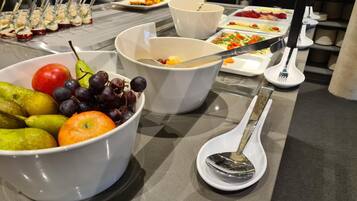 A buffet table with various food items and utensils.