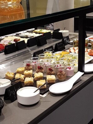 Un bufé con diferentes platillos y postres.