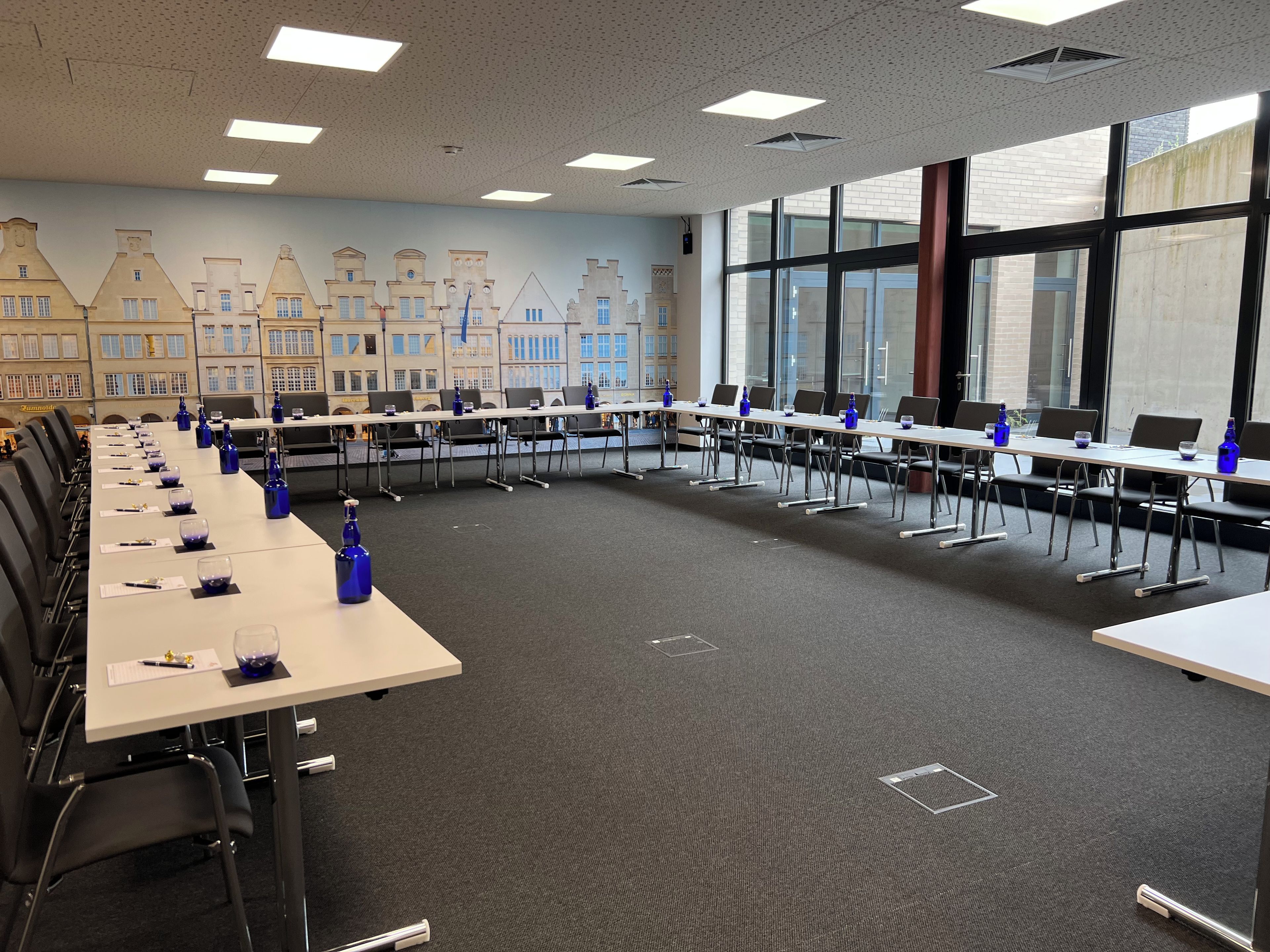 A conference room with a long table, chairs, and blue water bottles.