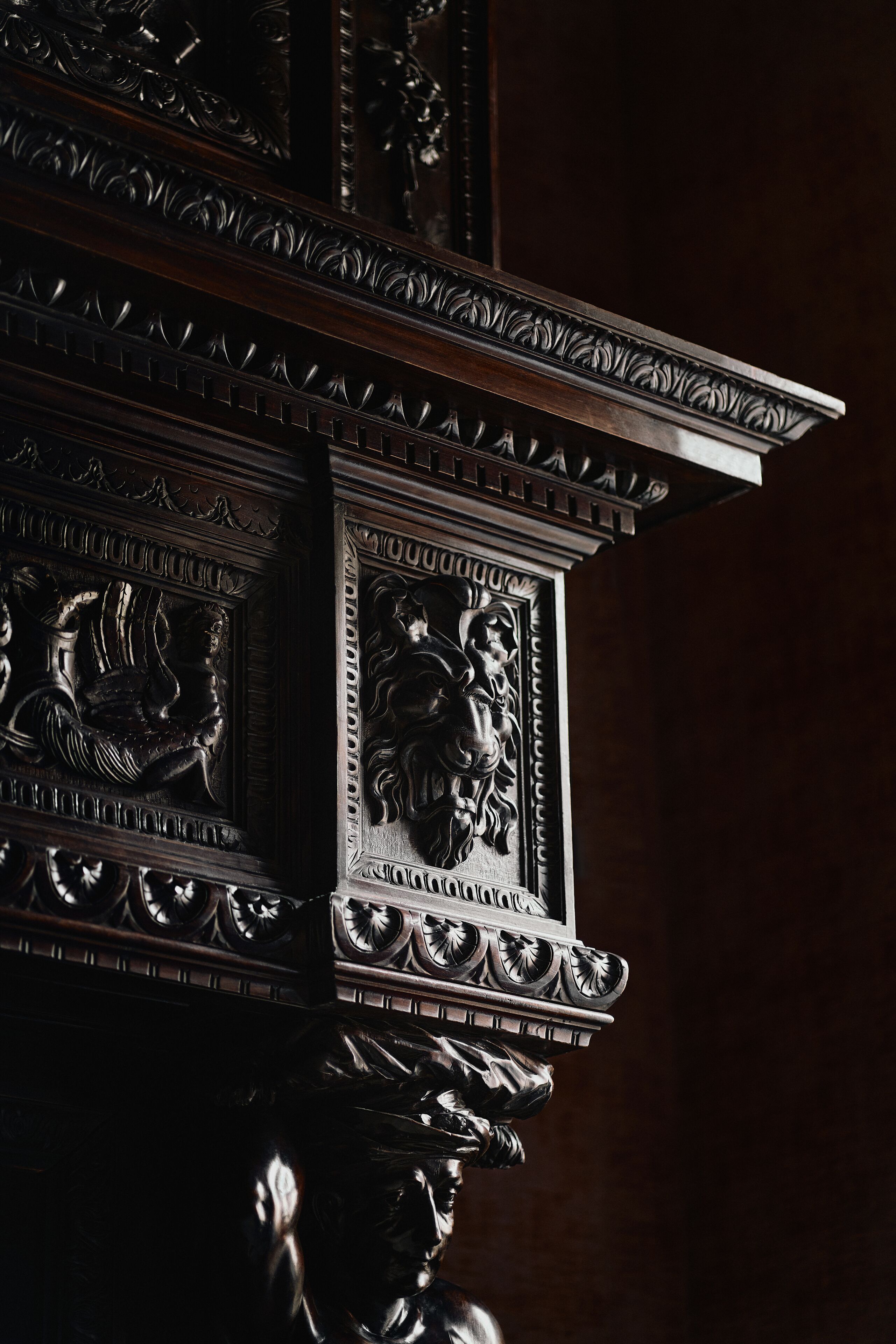 Un colonnato in legno finemente intagliato, con decorazioni elaborate e un motivo raffigurante un leone.