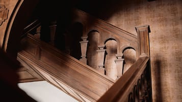 A grand staircase with ornate wooden railings and a vaulted ceiling.