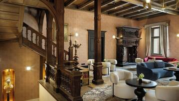 A spacious lobby with a grand staircase, a fireplace, and modern seating areas.