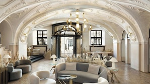 Un interior lujoso con un imponente techo abovedado, muebles elegantes y un candelabro.