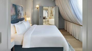 Una habitación de hotel espaciosa con una cama grande, un baño moderno y vistas a la ciudad.