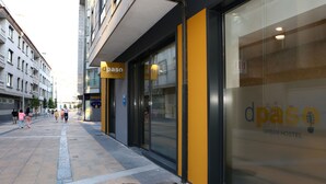 An urban hostel with a glass facade and a yellow accent wall. - dpaso Urban Hostel (Pontevedra)