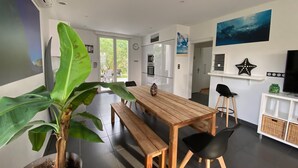 A modern kitchen with a wooden table and benches, a potted plant, and a view to the outside. - Villa Sandy Beach - Capbreton (Capbreton)