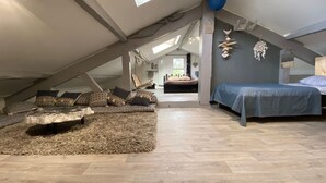 A loft bedroom with a high ceiling, a hanging chair, a bed, and a view of the outdoors. - Villa Sandy Beach - Capbreton (Capbreton)