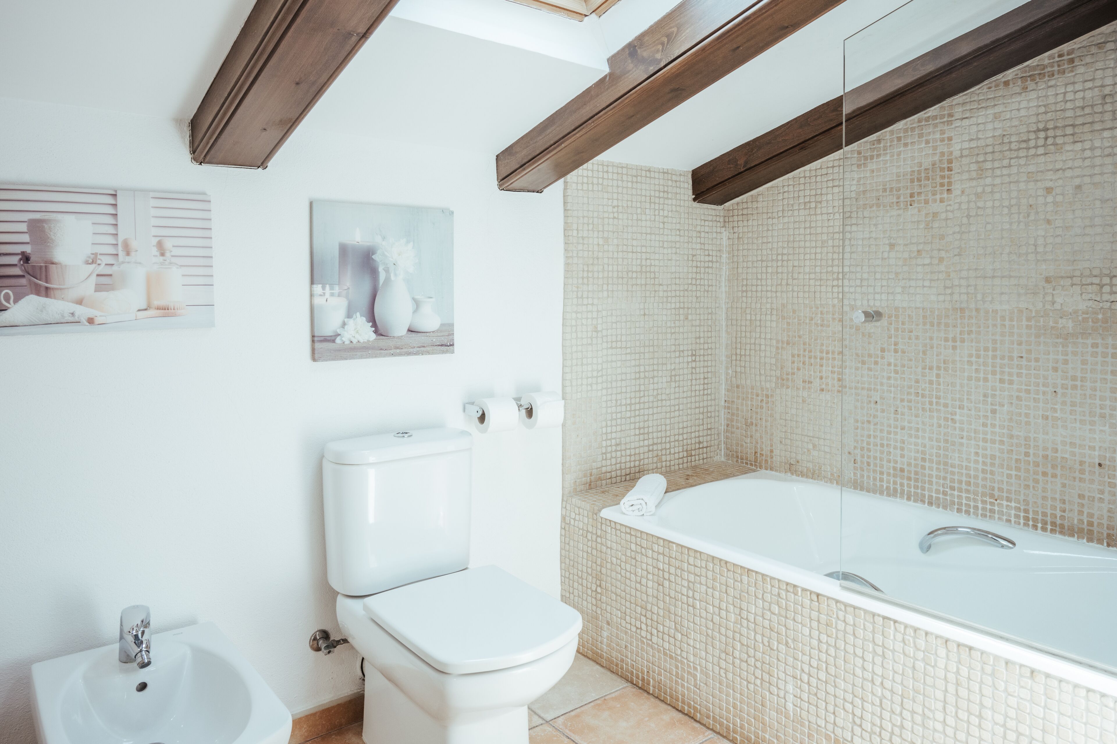 A bathroom with a toilet, bidet, and bathtub.