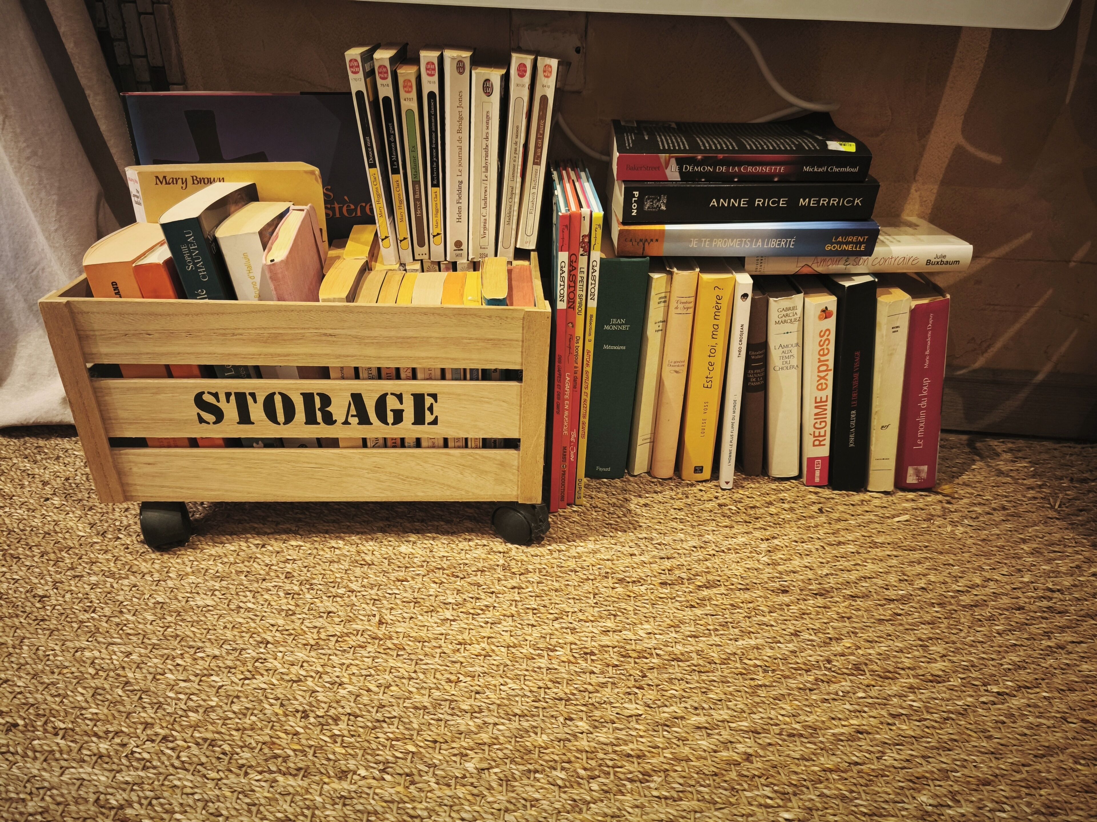 Ein hölzerner Rollwagen mit der Aufschrift 'STORAGE', gefüllt mit Büchern und einem kleinen Tisch mit weiteren Büchern.