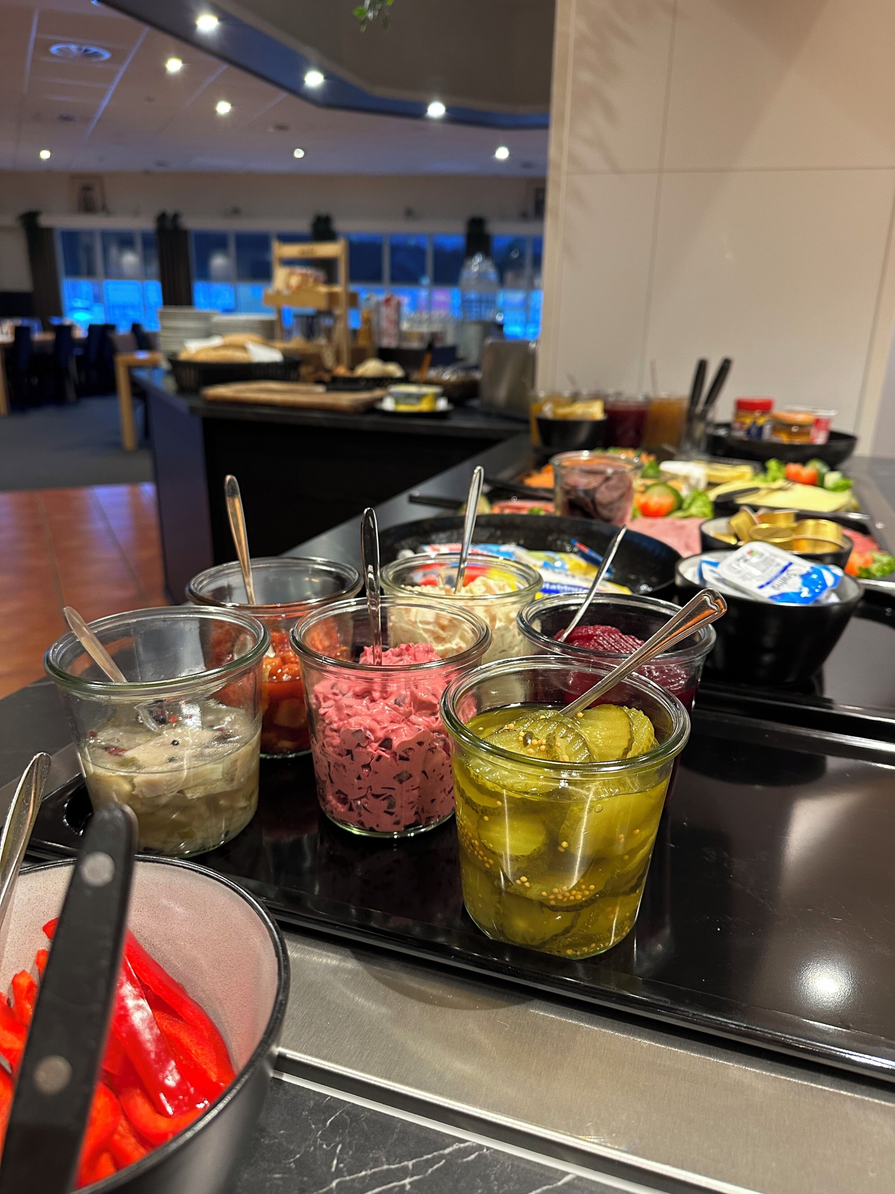 A buffet with various food items and condiments.