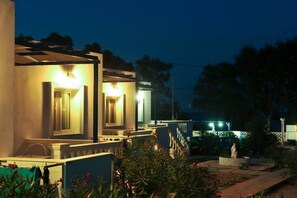 A hotel with multiple rooms, each with a balcony and a small garden area.