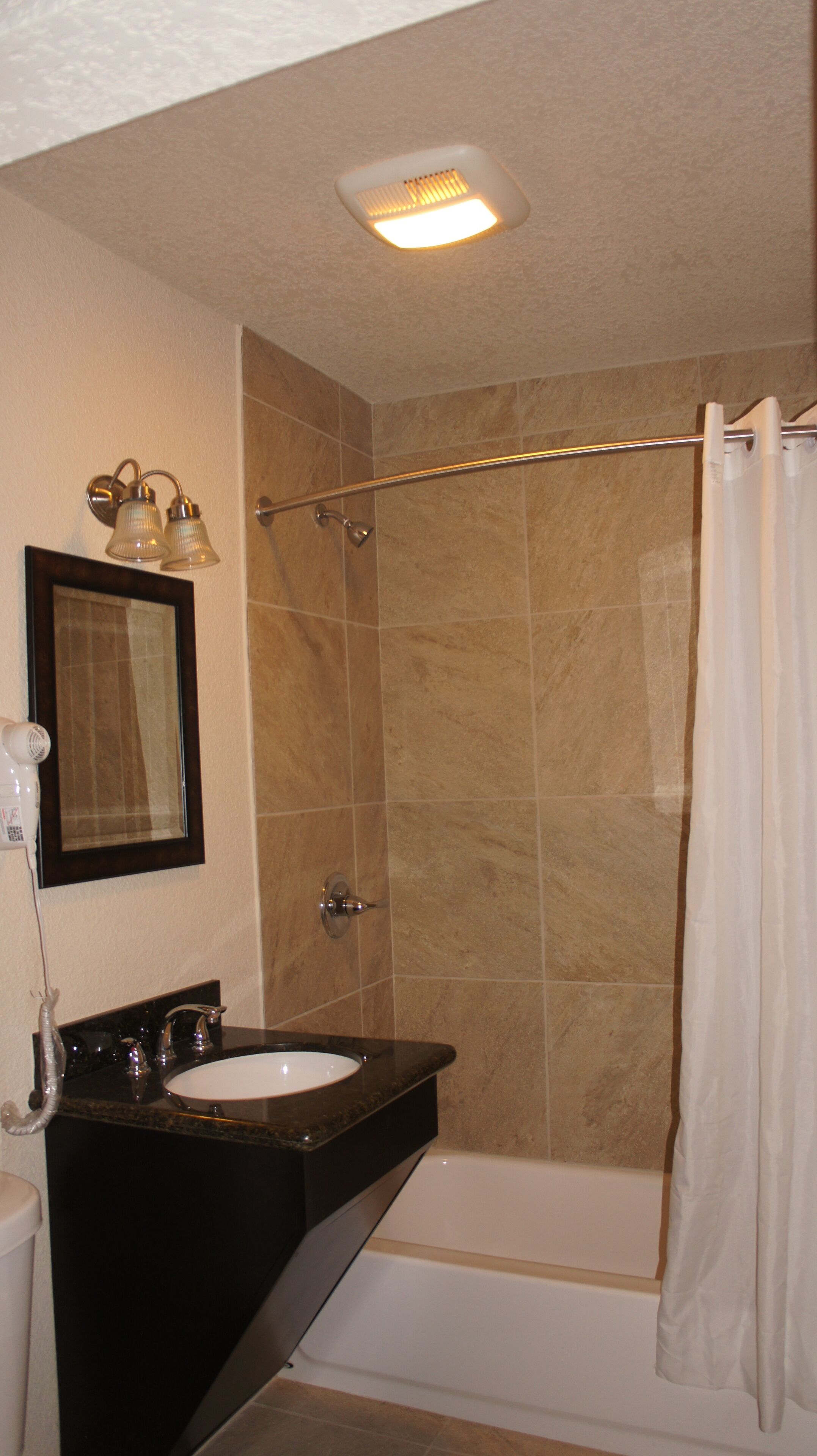 Une salle de bain avec un lavabo, un miroir et une douche.