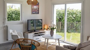 A modern living room with a TV, sofa, and dining area.