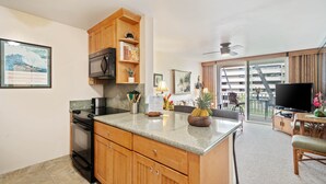 A modern kitchen with granite countertops, wooden cabinets, and a built-in microwave.