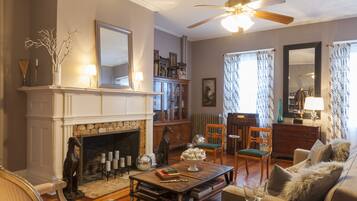 A living room with a fireplace, books, a coffee table, and a sofa.