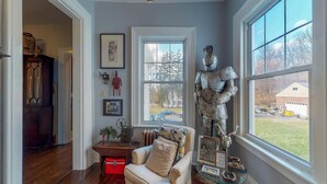 A room with a large window, a statue, and a small table with various items. - Gardner Farm Inn (Troy)