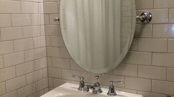 A bathroom with a white sink, a mirror, and a shower curtain.