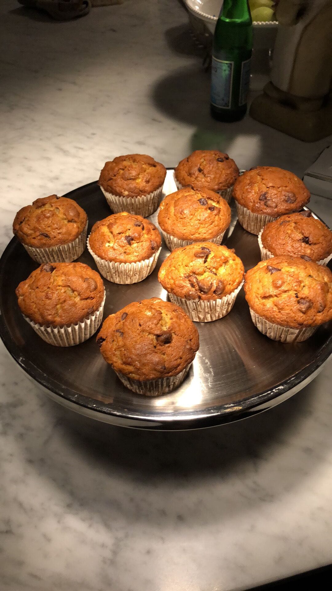 Uma bandeja de muffins recém-assados em uma bancada de cozinha.