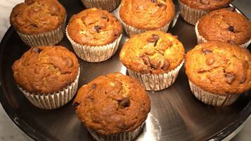 A tray of freshly baked muffins on a kitchen counter.