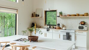 Una cocina moderna con una isla grande, sillas de madera y vistas al exterior.