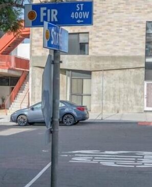 A street sign for FIR ST 400W with a car parked nearby. - PodShare San Diego - Hostel (San Diego)