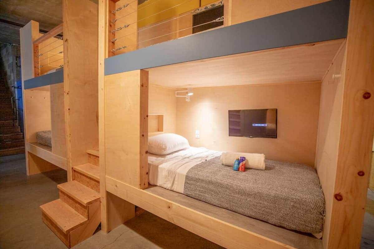 Une chambre avec un lit superposé, et un téléviseur placé sur le lit du bas.