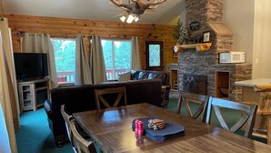 A cozy cabin interior with a stone fireplace, wooden furniture, and a television. - Bryce & Zion midpoint!  Firepit & pool table. ATV trails nearby. (Alton)