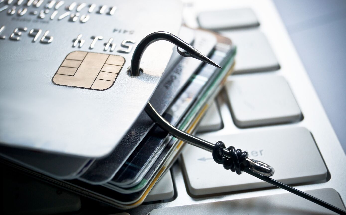 Une carte de crédit dotée d’un dispositif de sécurité et d’un câble USB branché sur le clavier d’un ordinateur portable.