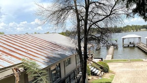 Un bâtiment doté d’un toit en métal, d’un quai et d’une zone abritée au bord de l’eau.
