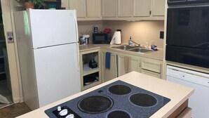 Une cuisine équipée d’une cuisinière, d’un réfrigérateur, d’un four à micro-ondes et d’un lave-vaisselle.