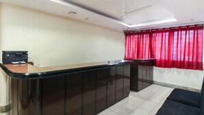 A hotel room with a kitchenette, a ceiling fan, and a red curtain. - OYO 70733 Hotel Regal (Hyderabad)