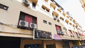 A multi-story building with air conditioning units, a sign for a men's bar, and closed shop shutters. - OYO 70733 Hotel Regal (Hyderabad)
