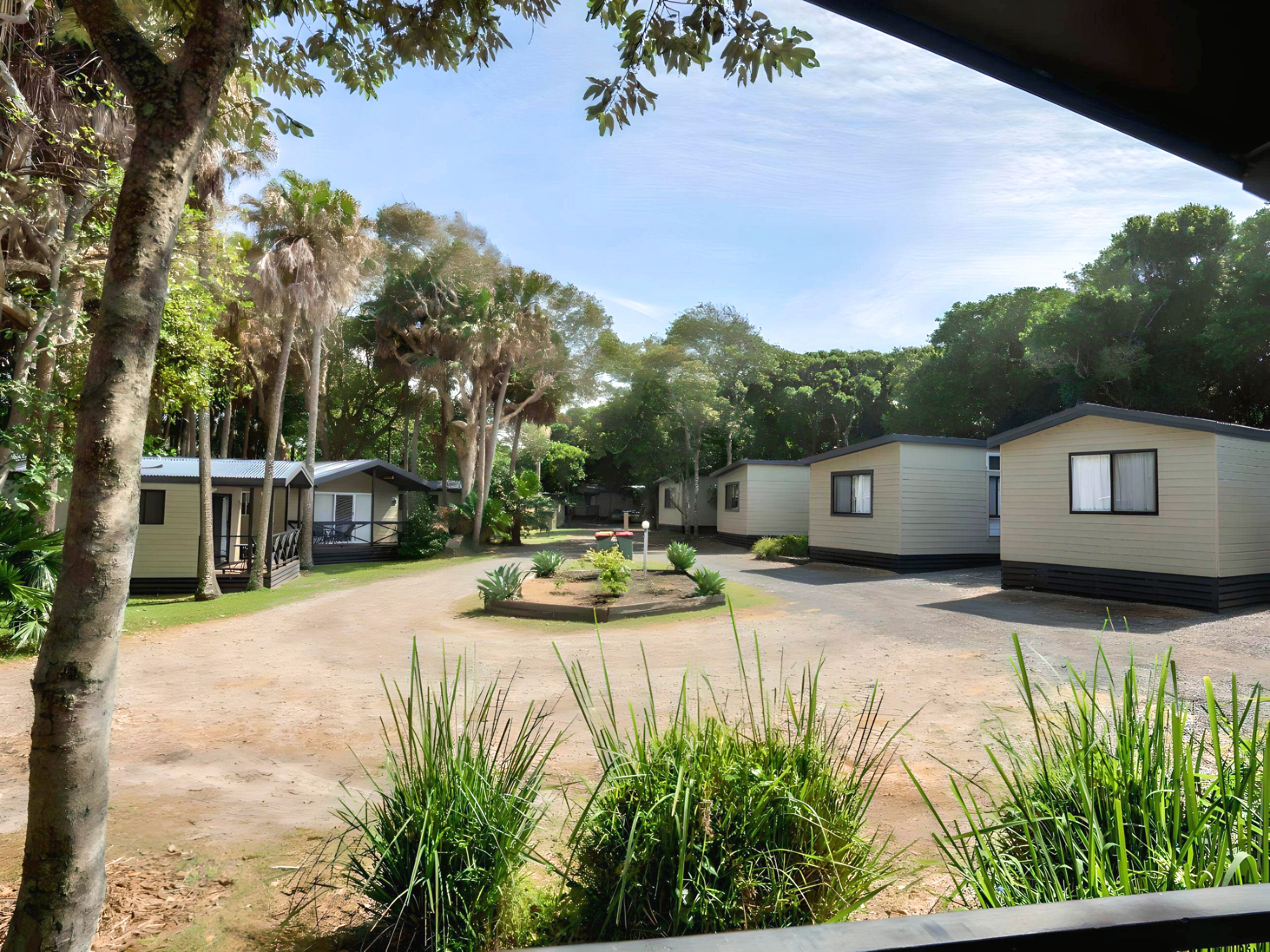 A campground with several mobile homes, surrounded by trees and greenery.
