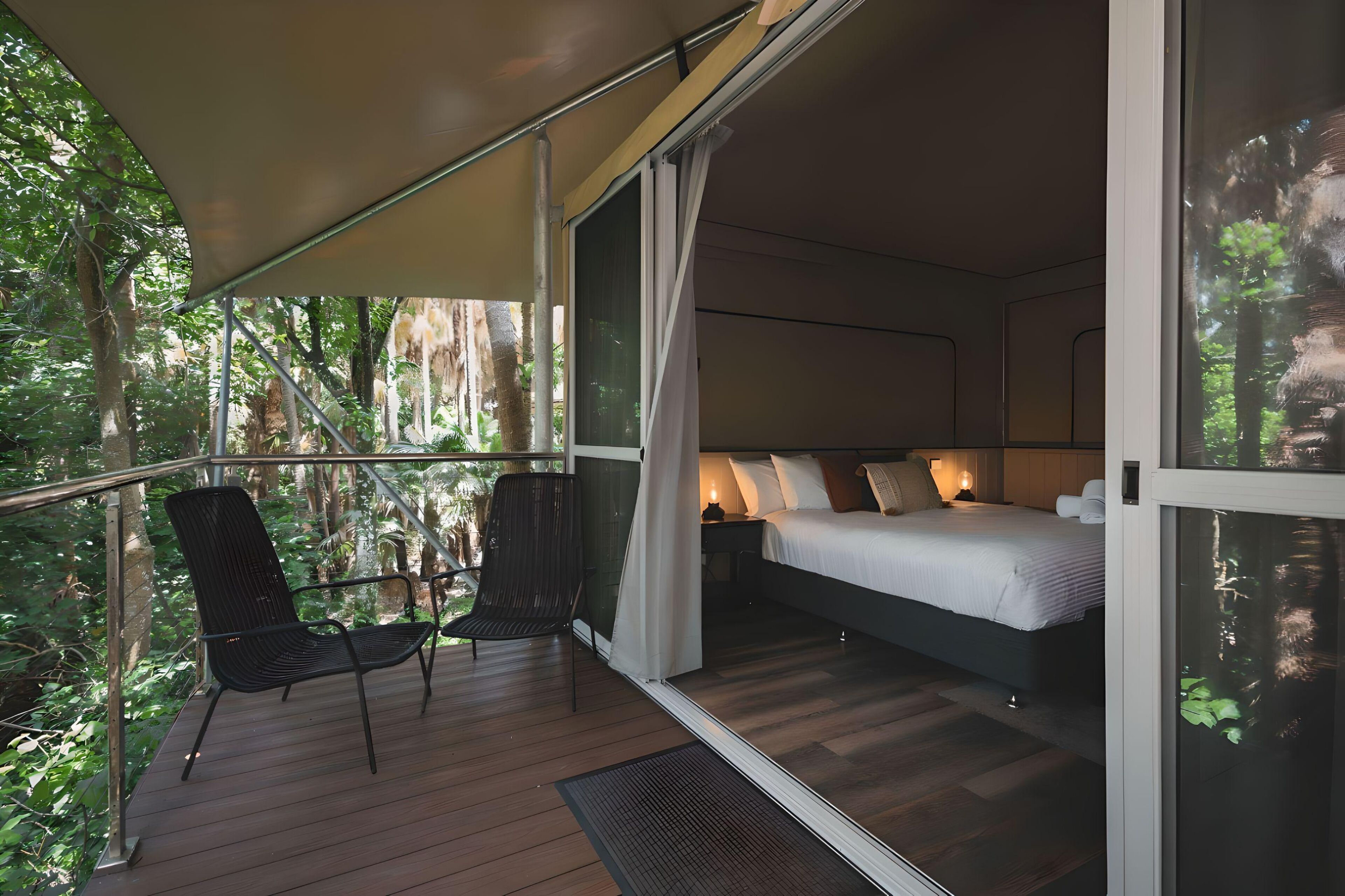 A bedroom with a bed, a chair, and a nightstand.