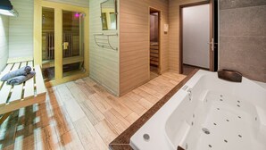 A modern bathroom with a wooden sauna, a large bathtub, and a shower area. - Charming Cottage with Hot Tub & Sauna, High Fens (Waimes)