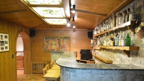 A bar area with wooden shelves stocked with bottles, a marble counter, and a stained glass ceiling. - Romantic Mansion in Strotzbusch by the Forest (Strotzbusch)
