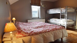A bedroom with a single bed, a bedside lamp, a window with blinds, a radiator, and a bunk bed in the corner. - Stone-built Holiday Home in Dinant With Terrace (Dinant)