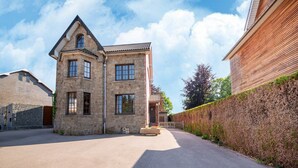A two-story stone building with a sloped roof and multiple windows. - Ludogite: Lover's Retreat (Waimes)