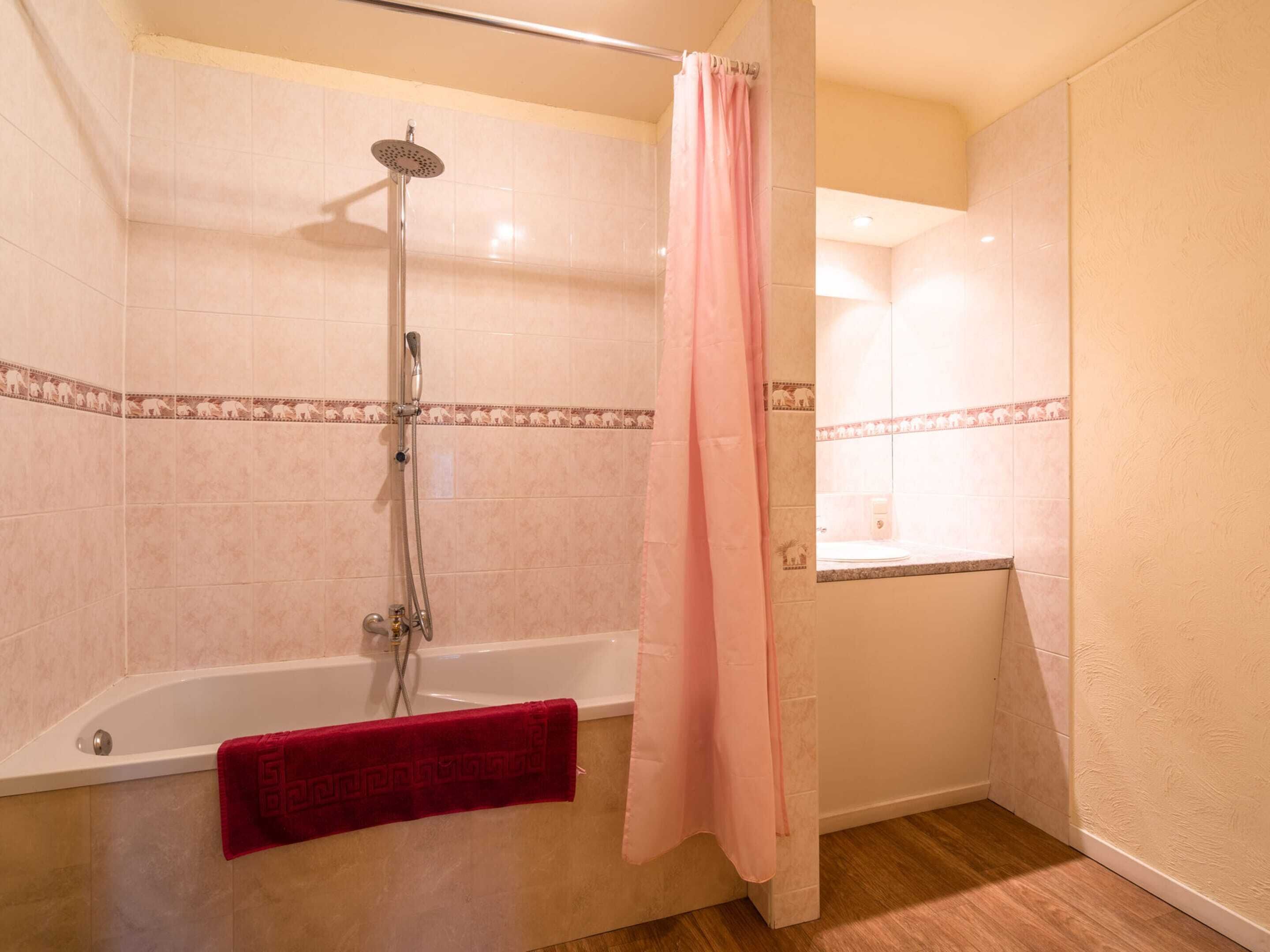 A bathroom with a shower, a bathtub, and a toilet.