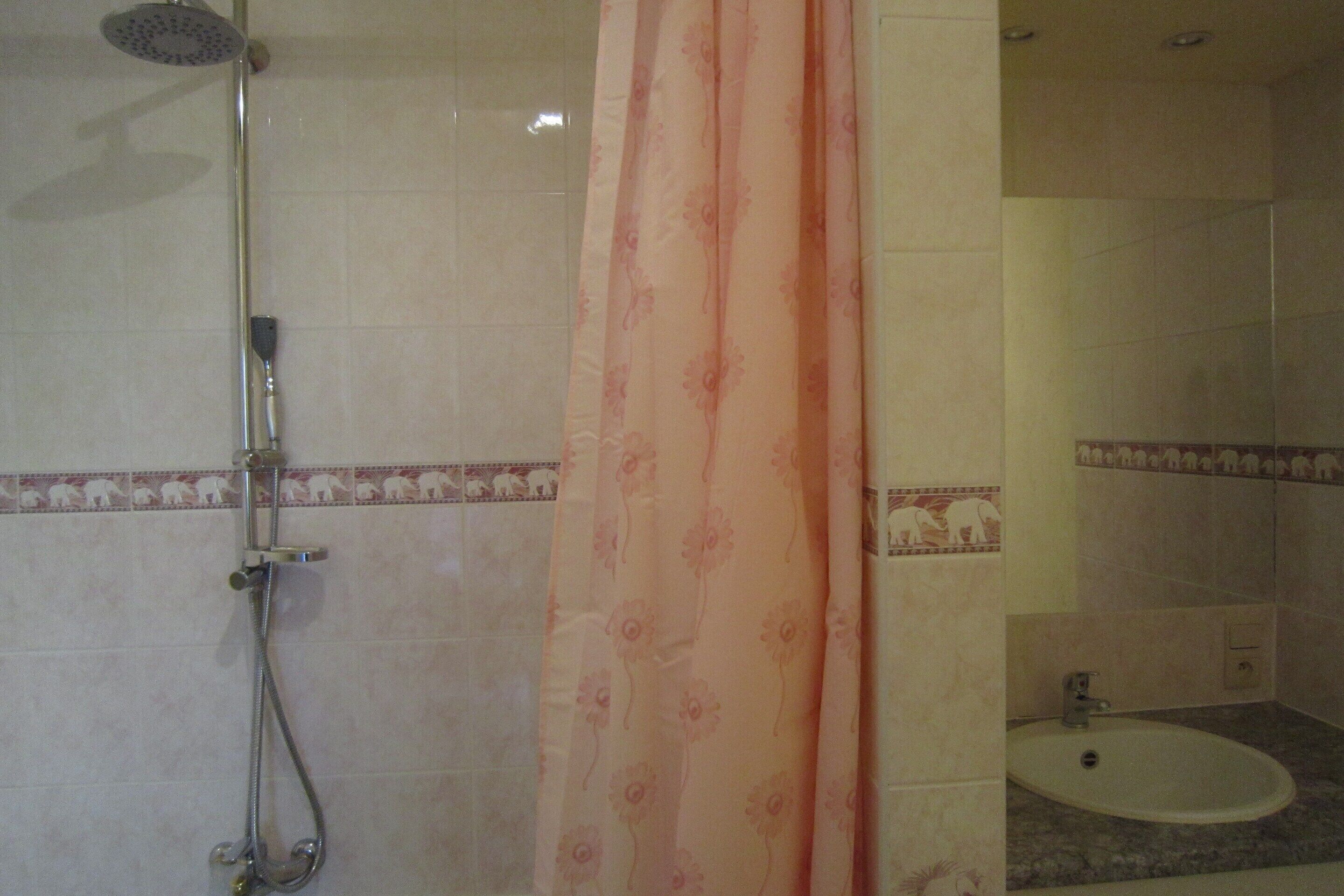 Une salle de bain avec une douche, un lavabo et des toilettes.