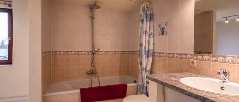 A bathroom with a bathtub, toilet, and sink.