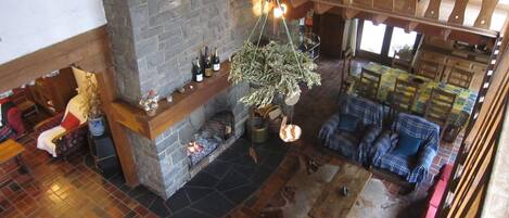 A spacious living area with a stone fireplace, wooden furniture, and a view of the outdoors.