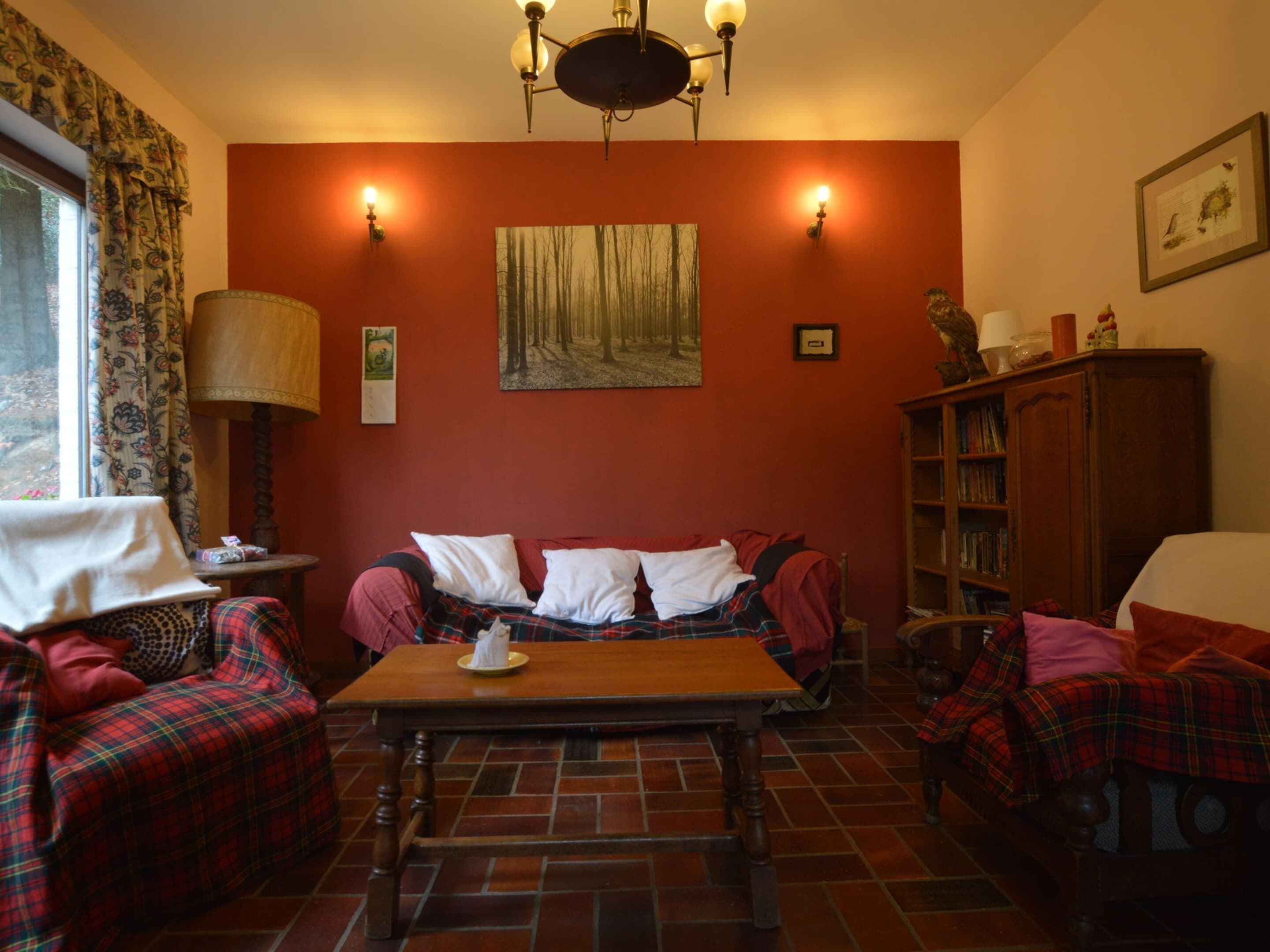 A cozy living room with a fireplace, a sofa, a table, and a bookshelf.