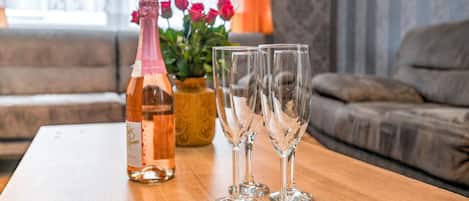 A wooden table with a bottle and three glasses on it.