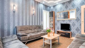 A living room with a grey sofa, a wooden coffee table, a TV, and a decorative mirror. - Picturesque Villa in Medebach near Ski Area (Medebach)